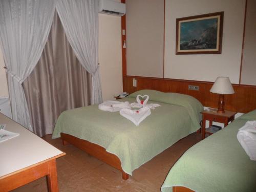 a hotel room with two beds with towels on them at Hotel Thermas Lagoa Santa in Lagoa Santa