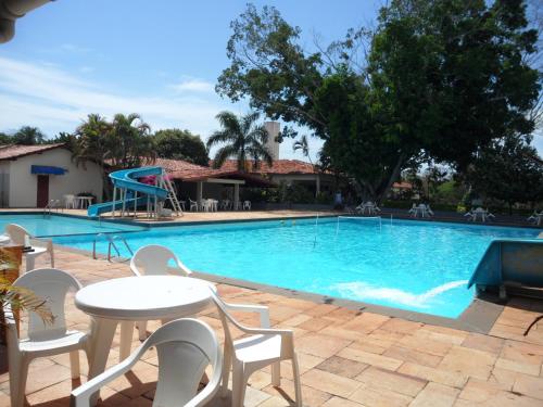 uma piscina com mesa e cadeiras e um parque infantil em Hotel Thermas Lagoa Santa em Lagoa Santa