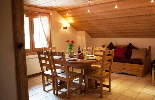 a dining room with a table and chairs and a couch at Les Azalées 6 in Les Gets