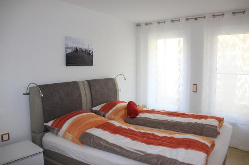 2 Betten in einem Zimmer mit weißen Wänden und Fenstern in der Unterkunft Villa Gutenberg in Binz