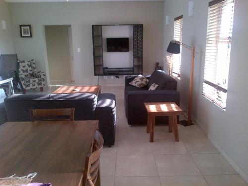 a living room with two couches and a table at Marina Martinique Selfcatering in Jeffreys Bay