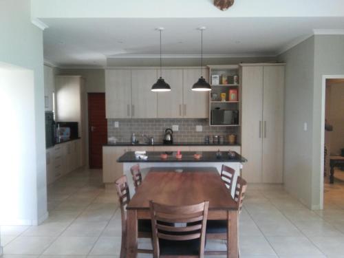 a kitchen with a table and chairs in a room at Marina Martinique Selfcatering in Jeffreys Bay