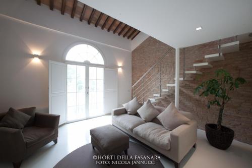 a living room with a couch and a staircase at Horti Della Fasanara in Ferrara