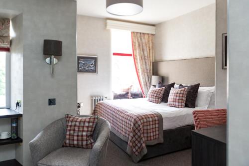 a hotel room with a bed and a chair at The Dowans Hotel of Speyside in Aberlour