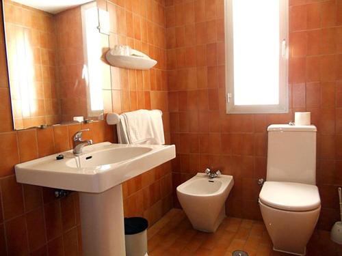 a bathroom with a sink and a toilet at Hostal Cortes in Cuenca