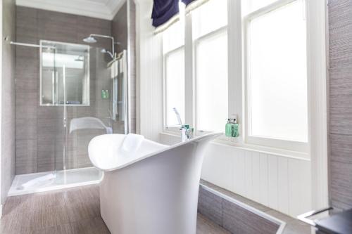 a white bathroom with a sink and a shower at The Dowans Hotel of Speyside in Aberlour