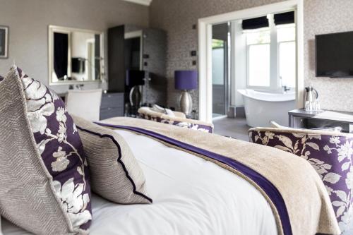 - une chambre avec un lit et une salle de bains avec une baignoire dans l'établissement The Dowans Hotel of Speyside, à Aberlour