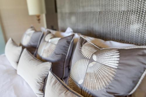 a row of pillows on a bed with a head board at The Dowans Hotel of Speyside in Aberlour