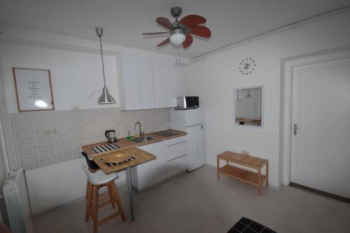 a kitchen with white cabinets and a ceiling fan at Jazzy Apartment Zagreb in Zagreb