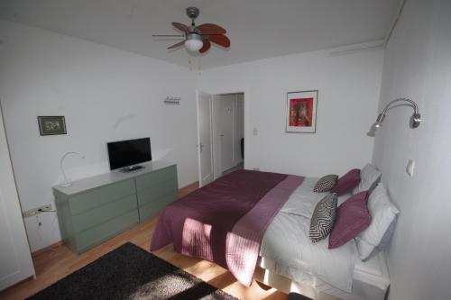a bedroom with a bed and a flat screen tv at Jazzy Apartment Zagreb in Zagreb