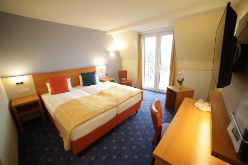 a hotel room with a bed and a table at Berghotel Tambach in Tambach-Dietharz