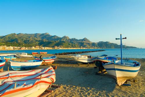 a group of boats sitting on the beach at Sporting Baia Hotel in Giardini Naxos