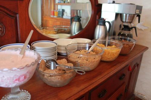 a counter with bowls of food and a mirror at Central Hotel Guest House in Simonʼs Town