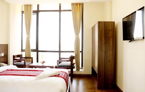カトマンズにあるHotel Kathmandu Innのベッド2台とテレビがあるホテルの部屋
