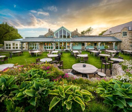 a building with tables and chairs in a garden at Black Horse Beamish in Stanley