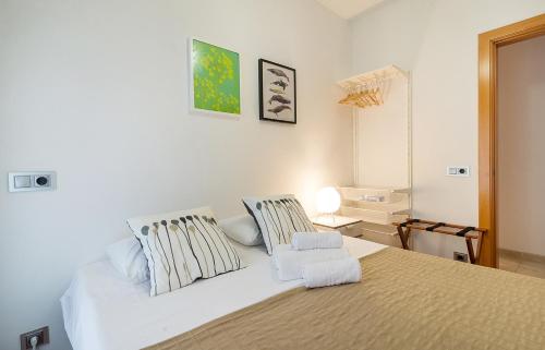 a bedroom with a large white bed with two pillows at Beach Town House in Vilassar de Mar