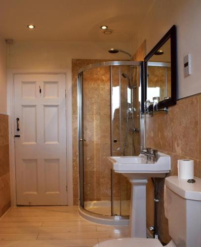 a bathroom with a shower and a sink and a toilet at Healds Hall Hotel in Cleckheaton