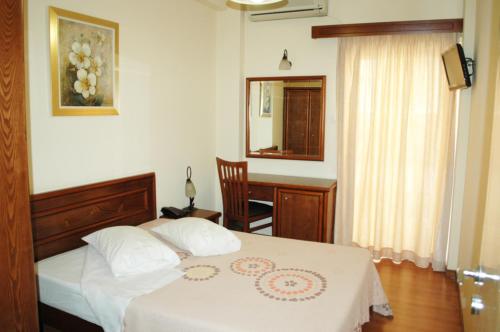 a bedroom with a bed with a table and a desk at Omiros Hotel in Athens