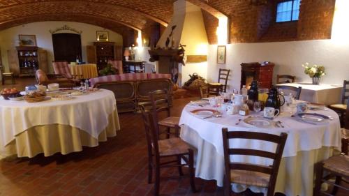 a dining room with two tables with white tablecloths at Marchesi Incisa Winery Lodge in Rocchetta Tanaro