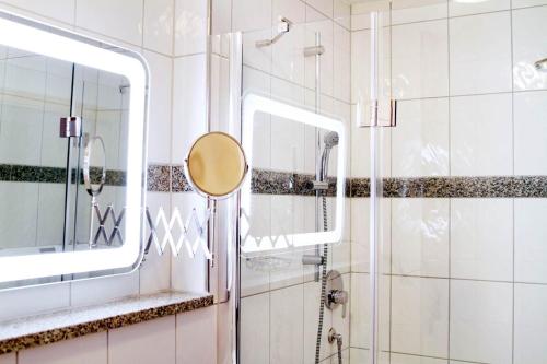 a bathroom with a shower and a mirror at Hotel Pension Kaempfelbach in Königsbach-Stein