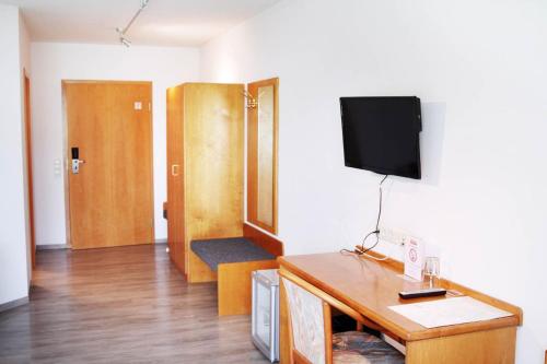 a living room with a tv on a wall at Hotel Pension Kaempfelbach in Kämpfelbach