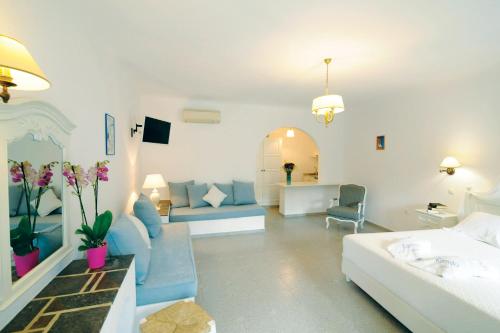 a living room with a couch and a living room with a couch at Kamari Hotel in Platis Yialos Mykonos