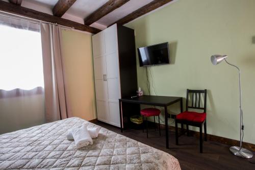 a bedroom with a bed and a desk and a television at Osteria alle Risorgive in Codroipo