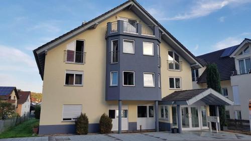 a yellow and gray house with a black roof at Hotel Pension Kaempfelbach in Kämpfelbach