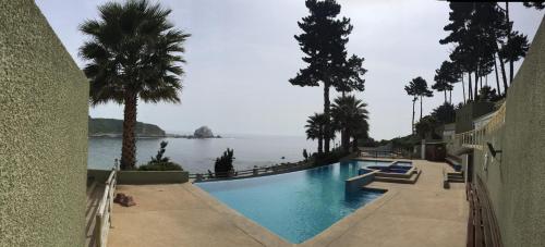 a swimming pool with a view of the water at Departamento en la Playa in Algarrobo