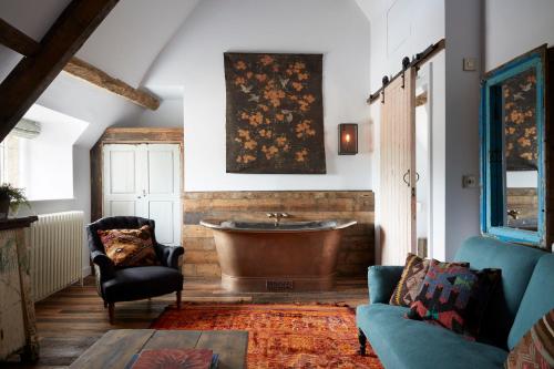 a living room with a tub and a couch at Artist Residence Oxfordshire in Oxford