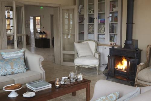 a living room with a fireplace and white furniture at Botanica in Dánszentmiklós