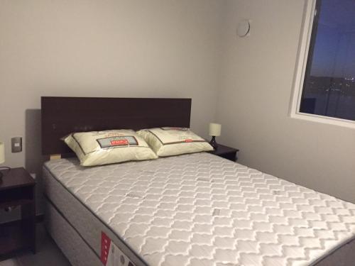 a bedroom with a bed with a white mattress at Apto Bahia Horizonte - La Herradura in Coquimbo