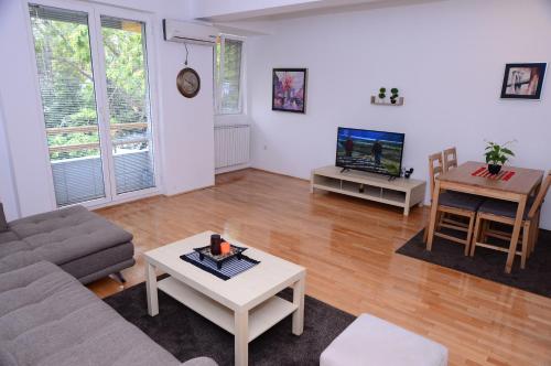 uma sala de estar com um sofá e uma mesa em Exclusive Skopje Apartments em Skopje