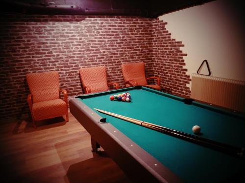 a room with a pool table and two chairs at Gasthaus Patruuna in Joutseno