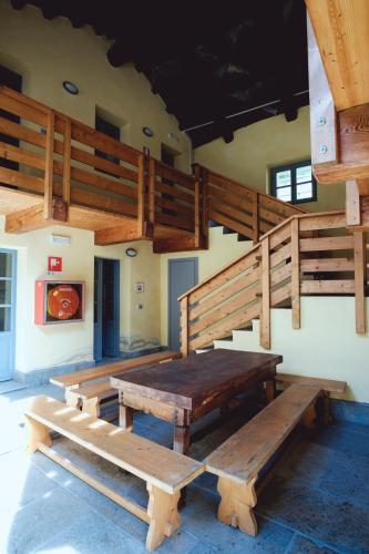 a large wooden table in a room with stairs at Certosa 1515 in Avigliana