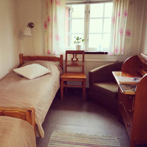 a bedroom with a bed and a couch and a window at STF Långasjö Vandrarhem in Långasjö