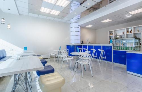 a room with blue and white tables and stools at Hotel Orbital in Obninsk