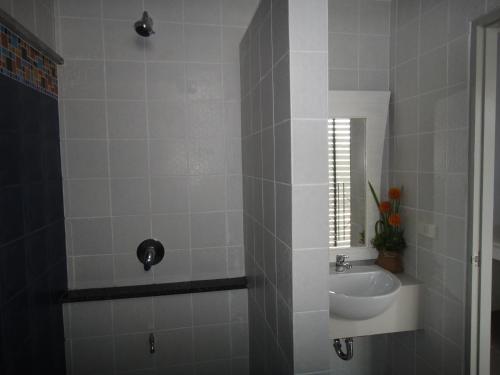 a white bathroom with a sink and a mirror at Dinar Lodge in Bang Tao Beach