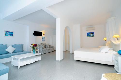 a white room with a bed and a couch at Kamari Hotel in Platis Yialos Mykonos