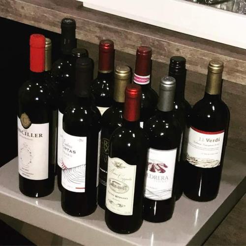 un mucchio di bottiglie di vino sedute su uno scaffale di Aldea Zen a Ouro Preto