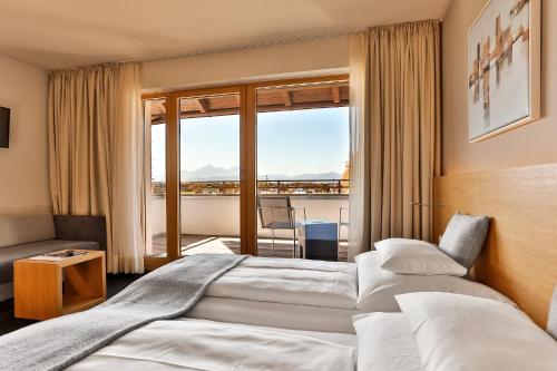 Habitación de hotel con 2 camas y balcón en Hotel-Restaurant Ammerhauser en Anthering
