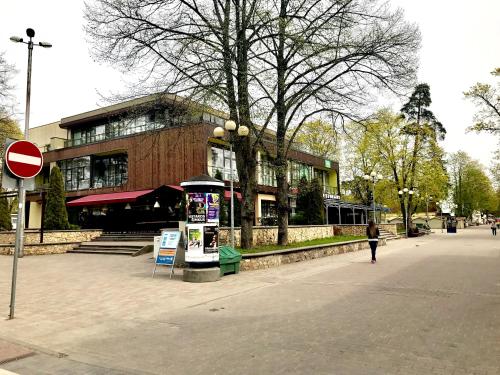 a woman walking down a street in front of a building at Jurmala's Center Eco House in Jūrmala