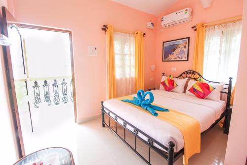 sypialnia z 2 łóżkami w pokoju z różowymi ścianami w obiekcie Hilias Retreat w mieście Palolem