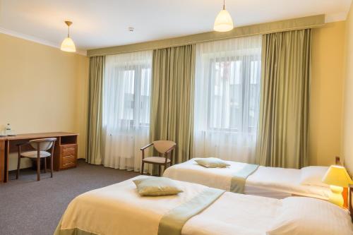 En eller flere senger på et rom på Hotel Patriarshyi