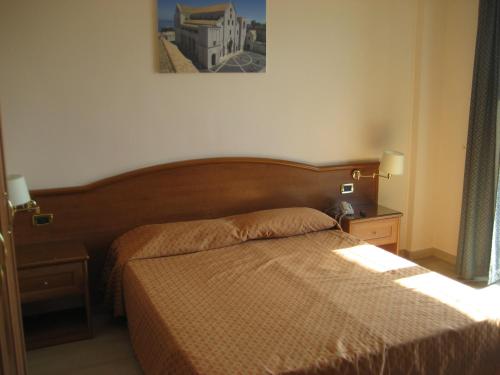 1 dormitorio con 2 camas y una foto en la pared en Campus Hotel, en Bari