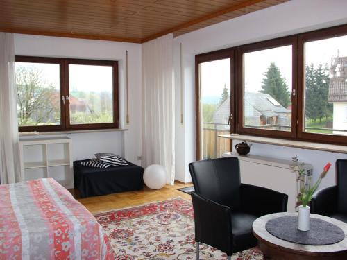 Schlafzimmer mit einem Bett, einem Tisch und Stühlen in der Unterkunft Vronis Ferienwohnungen in Mühlingen