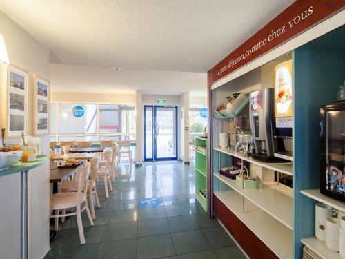 a kitchen with a counter and a dining room at B&B HOTEL Dieppe in Saint-Aubin-sur-Scie