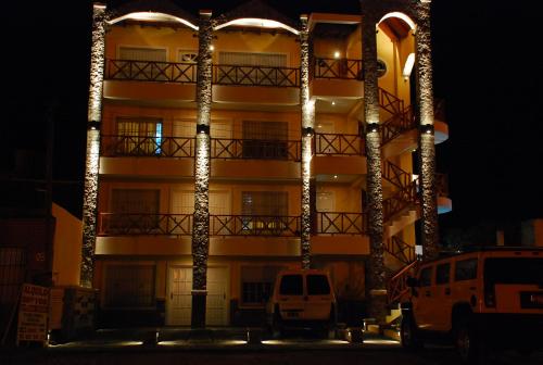 un bâtiment avec des lumières devant lui la nuit dans l'établissement Complejo Berilde II, à San Clemente del Tuyú