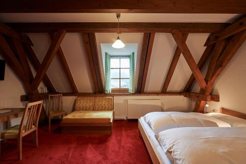 1 dormitorio con 2 camas, mesa y ventana en Seminar- und Gästehaus im Kloster Bezau, en Bezau