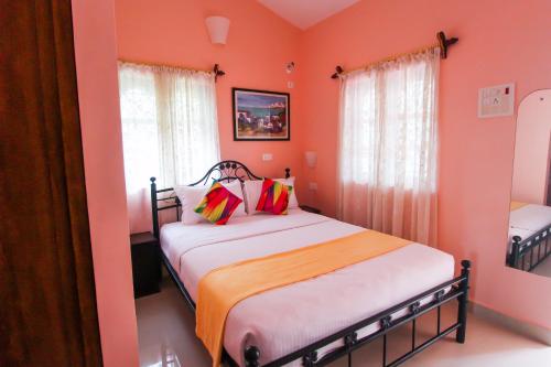 a bedroom with two beds with orange walls at Hilias Retreat in Palolem